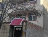 نمای ساختمان سنگی ودرب کوچک مشکی آپارتمان در زعفرانیه 5684848644