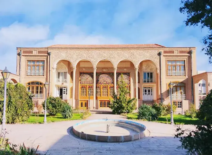 نمای بیرونی ساختمان قدیمی با نقش و نگار های زیبا و محوطه سازی سرسبز خانه بهنام تبریز در نزدیکی ارگ علیشاه 256231
