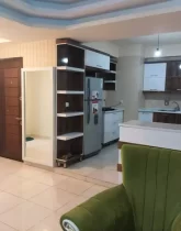 کابینت های سفید و قهوه ای رنگ و یخچال آشپزخانه آپارتمان در زعفرانیه